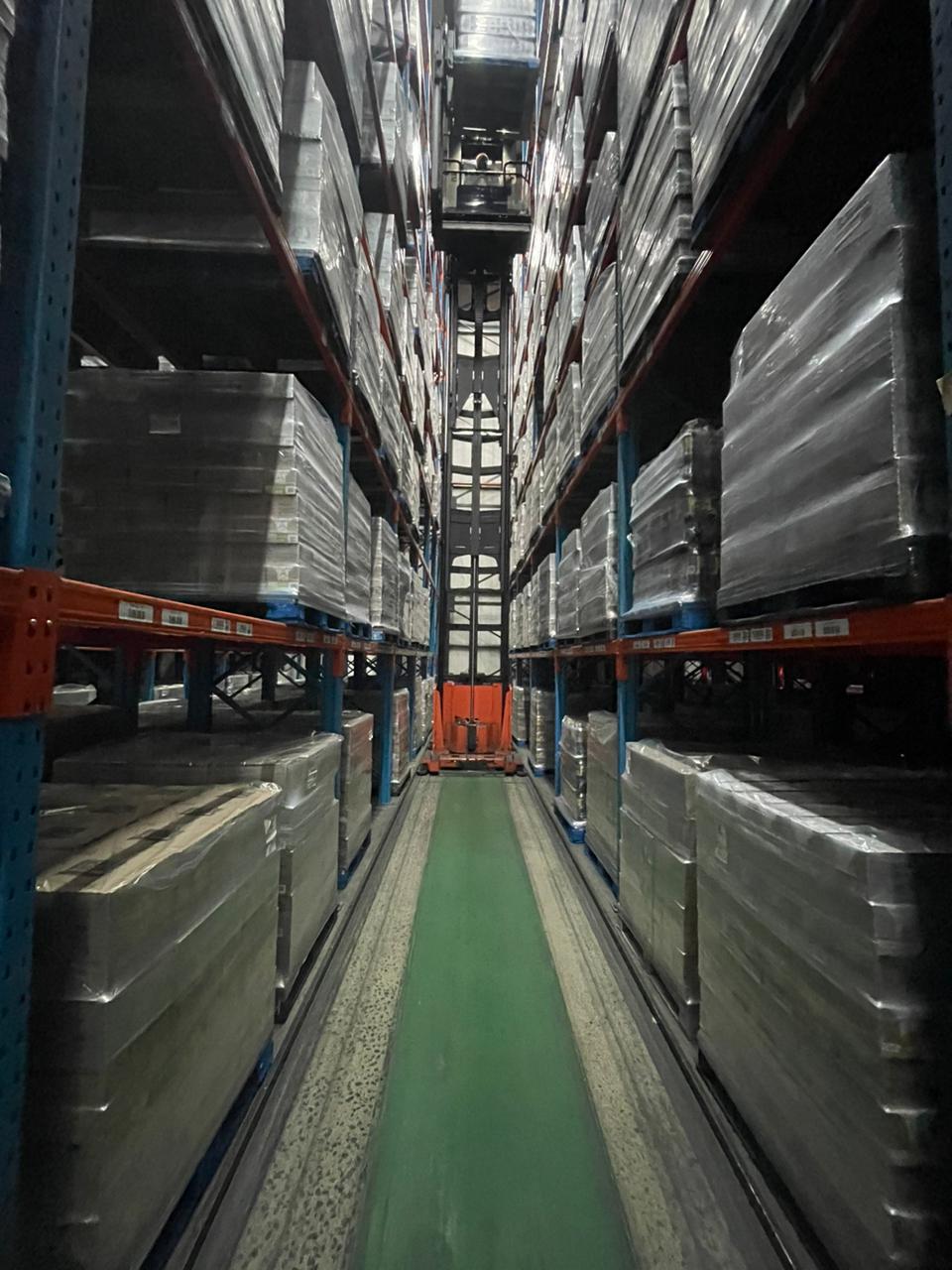 VNA reach truck operating between warehouse racking